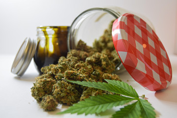 Dry and trimmed cannabis buds stored in a glas jars,a marijuana leave and a big BHO jar. Medical cannabis