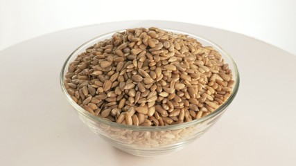 Nuts sunflower rotate are on a table in a plate. Snack in transparent dish on an isolated white background are spinning moving. Delicious and healthy protein-rich diet food.