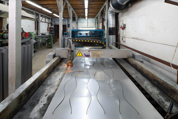 Plasma cutting of metal. Front view of working machine with sheet of metal. Metalworking.