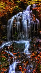 Fototapeta na wymiar Autumn waterfall in greenstone valley forest park, benxi, liaoning, China