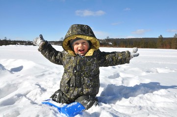  joyful little boy smiles while playing in the snow, mood of joy, happiness