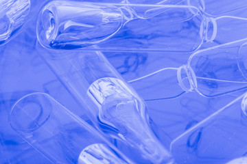 Glass medical ampoule vial for injection. Medicine is liquid sodium chloride with of aqueous solution in ampulla. Close up. Bottles ampule multicolor on background color and water. Human plasma.