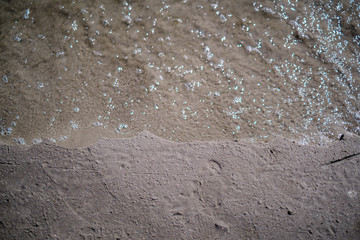frozen sea beach with sand and first snow in cloudy day