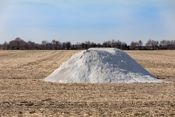 Pile of pulverized lime, limestone, fertilizer in bean field stubble waiting for fall application