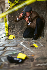 Vintage detective phoPhotographer with vintage camera at the crime scene.