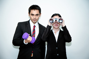 Business man who looks far away A woman with binoculars A man with a drumbell business concept.