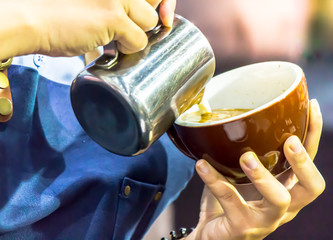 Showcase Barista making Latte art coffee and Barista pouring fresh milk create art pattern on Latte coffee at cafe.