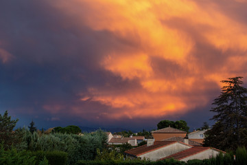 Fototapeta na wymiar Amazing composition of orange clouds over a village