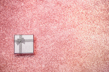 Fototapeta premium Silver gift box on the pink glitter sparkling background