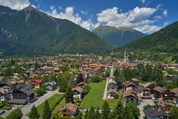 Fototapeta premium Aerial view of the ski resort Pinzolo, italy. Morning is the autumn season. In the background a clear blue sky