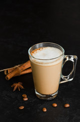 Glass of coffee with milk on black background. Hot latte or cappuccino in transparent mug. Morning beverage. A good start to the day concept. Close-up. Copy space