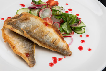 Fillet of fish with vegetables on a plate in a restaurant.