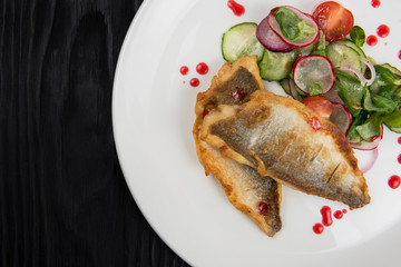 Fillet of zander with vegetables on a plate in a restaurant.