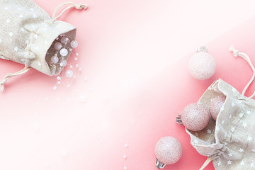 Holiday composition. Christmas balls and beads in cotton bags on a pink background. The concept of zero waste. Christmas, New Year concept. Top view, flat lay, copy space.