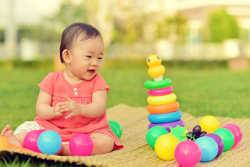 Cute Asian baby playing with toys in playground