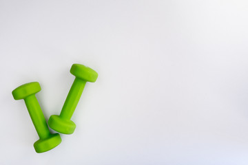 Two green dumbbells isolated on white background