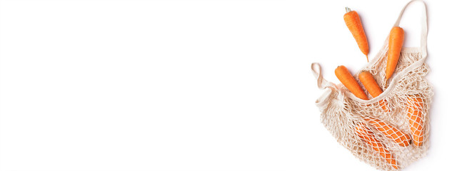 Fresh carrots in mesh eco shopping bag isolated on white