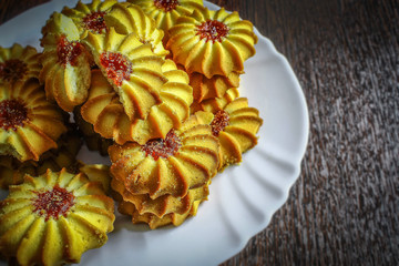 Fresh pastries in a white plate. Sweet cookies with jam closeup