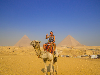 Tourist on camel in front of the Pyramids of Giza. In Cairo, Egypt