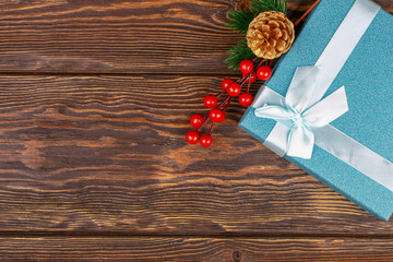 Christmas background. Gift box. Spruce branch. Christmas decorations. Brown background from boards. Top view. Close-up.