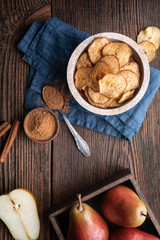 Fototapeta na wymiar Sweet delicious snack, homemade oven dried crispy pear chips sprinkled with cinnamon