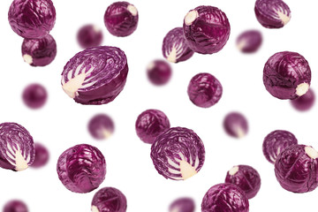 Falling red cabbage, isolated on white background, selective focus