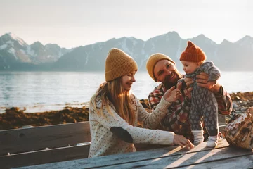 Fototapeten Glückliche Familie im Freien Mutter und Vater mit Baby reisen zusammen Urlaub Eltern spielen mit Kind gesunden Lebensstil Blick auf die Berge in Norwegen © EVERST