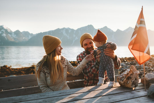 Family mother and father with baby traveling together vacation outdoor parents with child healthy lifestyle mountains view in Norway
