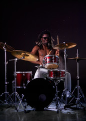 Fototapeta na wymiar portrait of african man performing music with use of drum set, handsome black naked man