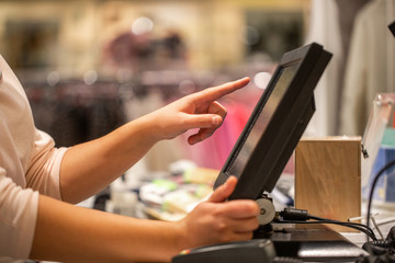 Young woman hands scaning / entering discount / sale on a receipt, touchscreen cash register,...