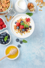 Homemade granola with yogurt and fresh berries, healthy breakfast concept, top view, flat lay.