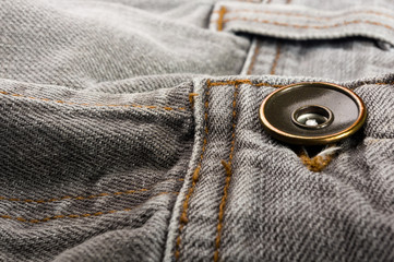 clothing items stonewashed cotton fabric texture with seams, clasps, buttons and rivets, macro