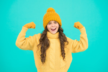 Energy charge. Child cute girl hat and gloves show biceps gesture of power and strength. Feel so powerful. Girls rules concept. Upbringing advices for girls. Strong and powerful. Excited about winter
