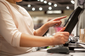 Young woman hands scaning / entering discount / sale on a receipt, touchscreen cash register, market / shop, finance concept, business