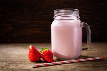 glass jar of strawberry smoothie with fresh berries