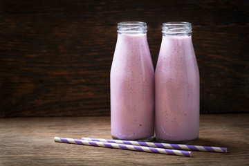 bottles of blueberry smoothie on a wooden table