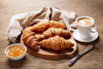 breakfast with cup of coffee, croissants and orange jam