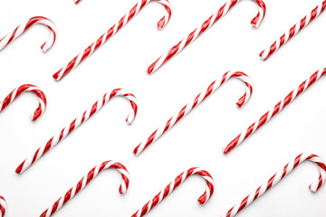 Pattern made with Christmas candy canes on white background. Minimal composition with peppermint candies. Top view