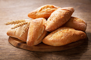 fresh bread with wheat ears on a wooden board