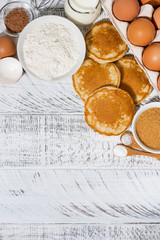 ingredients for baking pancakes on white wooden background, vertical top view
