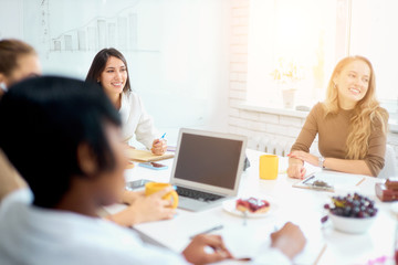 Obraz premium Young creative business ladies coworking in white modern office, wearing casual clothes. use laptop, modern technologies
