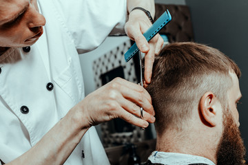 YOUNG HANDSOME BEARDED MAN IN BARBERSHOP