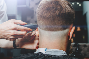 BARBER IS TRIMMING THE HAIRCUT