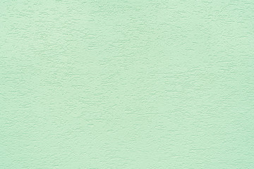Texture of concrete wall covered with decorative stucco with a rough surface and neon mint color cracks. The concept of the structure, texture, decor