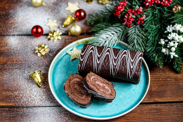 Sliced chocolate roll. Decorated with strawberries. Copy space. Christmas, New Year mood. Breakfast with a cup of coffee. 