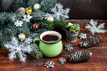 Obraz na płótnie Canvas Hot coffee in a large ceramic, green cup. Christmas toys. New Year mood. On a dark background. Symbol of the coming year. Copy space. 