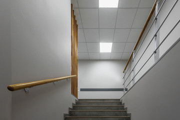 Background of gray staircase with wooden handrail in office building
