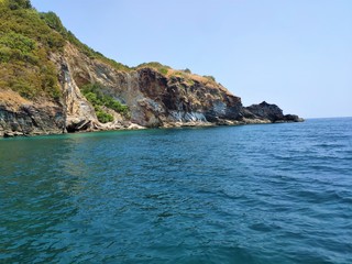 the landscape of blue sea and rocky mountains