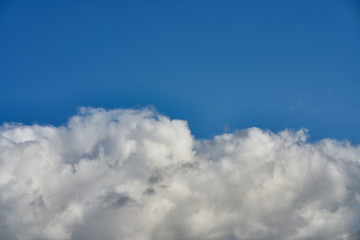 Fototapeta na wymiar huge clouds occupy the bottom of the photo against the blue sky