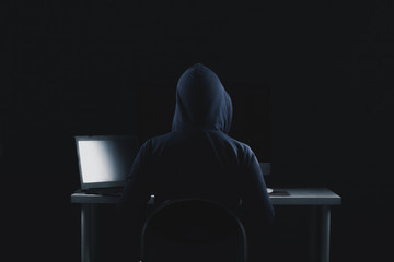 young guy behind a laptop, a hacker